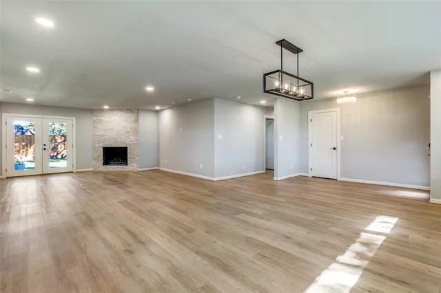 an empty room with windows and fireplace