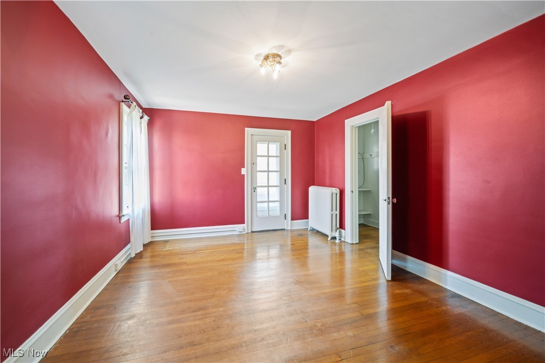 24510 Lake Road Bay Village, OH 44140 - Photo 40 of 45 Spare room with wood-type flooring and radiator heating unit