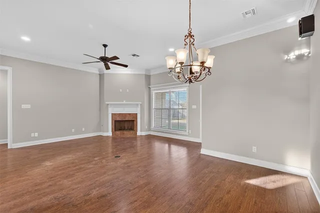 a view of a livingroom with a fireplace wooden floor and chandelier