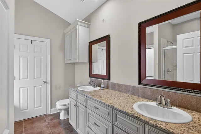 a bathroom with a granite countertop sink toilet and mirror