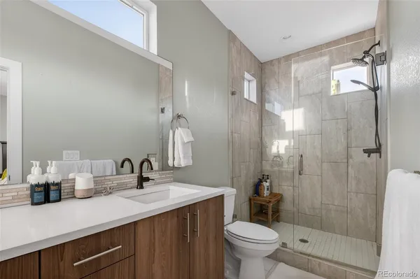 a bathroom with a sink a toilet and shower