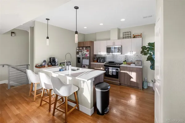 a kitchen with stainless steel appliances kitchen island granite countertop a sink a stove a dining table and chairs
