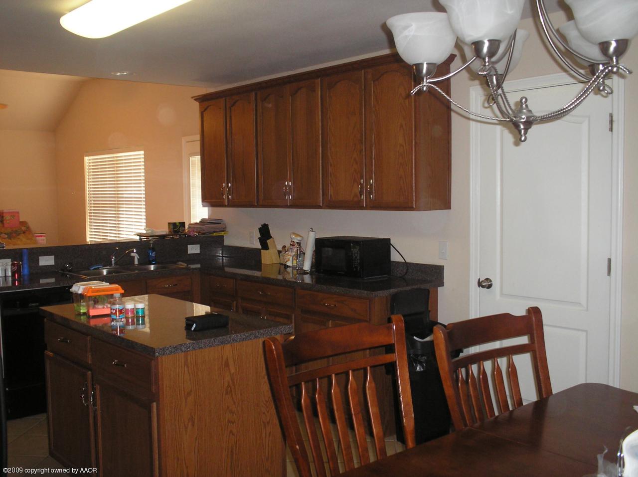 4804 Nimbus Lane Amarillo, TX 79110 - Photo 16 of 21 a kitchen with a sink cabinets and black appliances