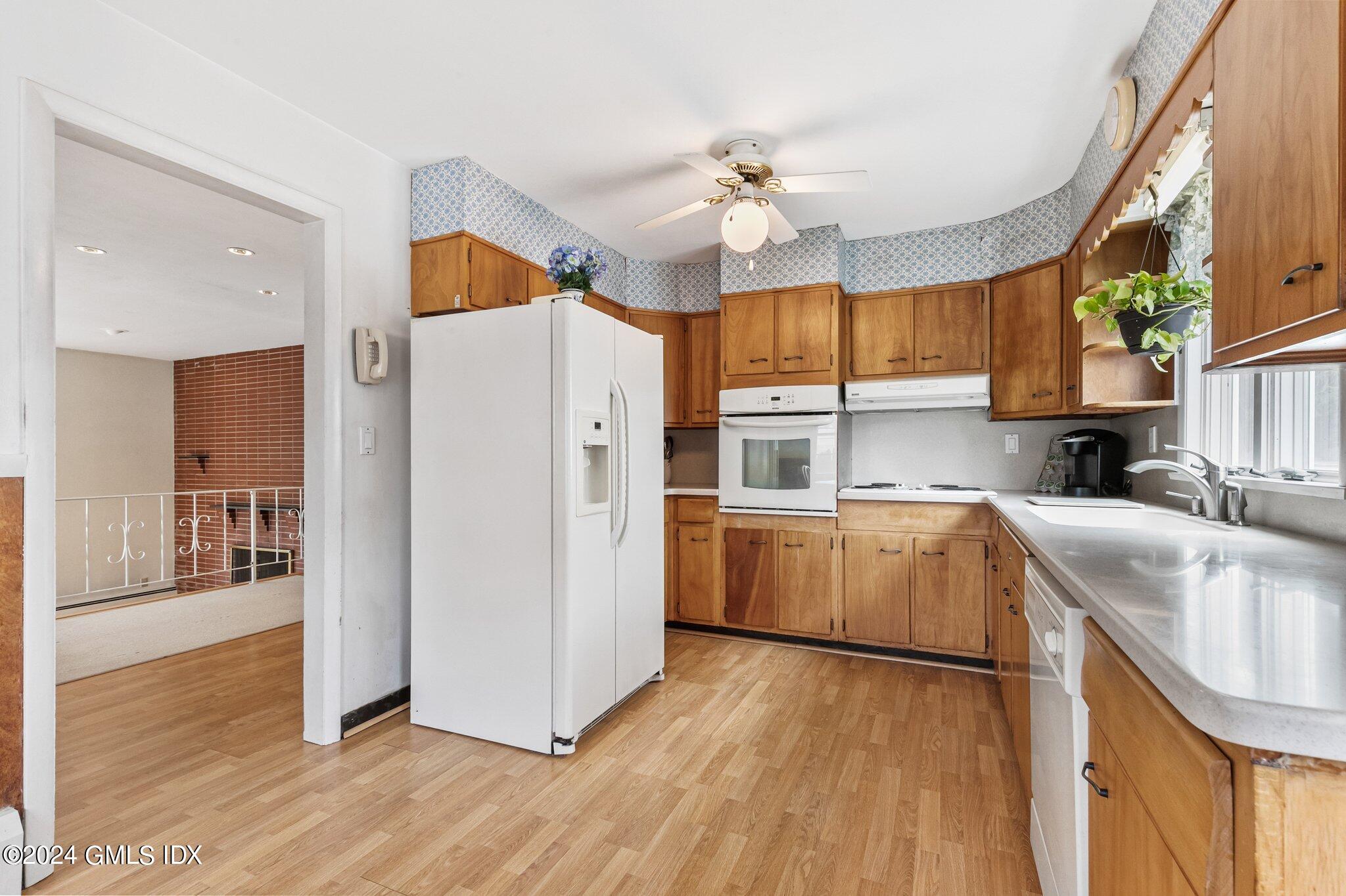15 Thorn Hill Road Riverside, CT 06878 - Photo 7 of 30 a kitchen with a refrigerator a sink and dishwasher with wooden floor