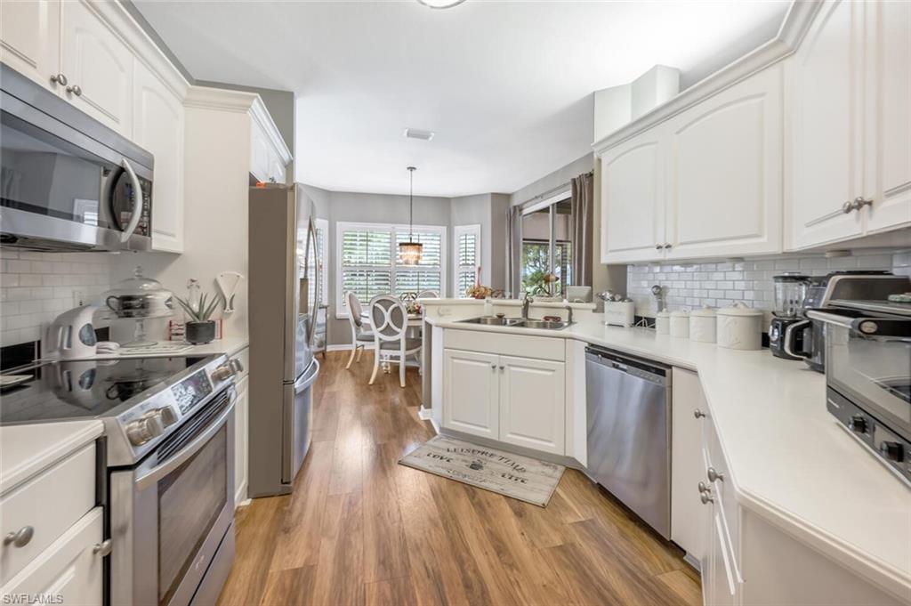 7005 Pinnacle Lane, Unit 1501 Naples, FL 34110 - Photo 12 of 45 a kitchen with a sink stove and cabinets