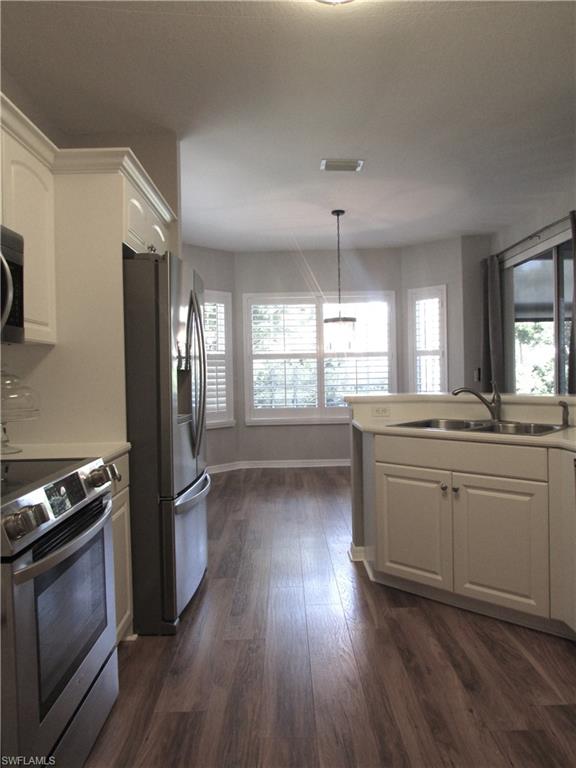 7005 Pinnacle Lane, Unit 1501 Naples, FL 34110 - Photo 15 of 45 a kitchen with granite countertop a stove a sink and a refrigerator