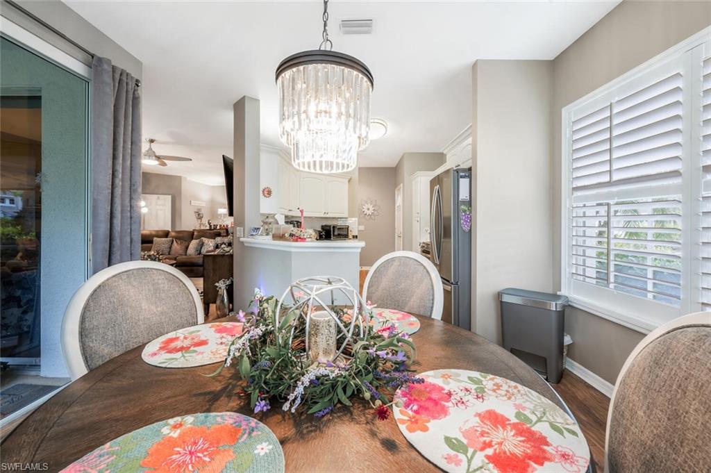 7005 Pinnacle Lane, Unit 1501 Naples, FL 34110 - Photo 17 of 45 a living room filled with furniture chandelier and a fireplace