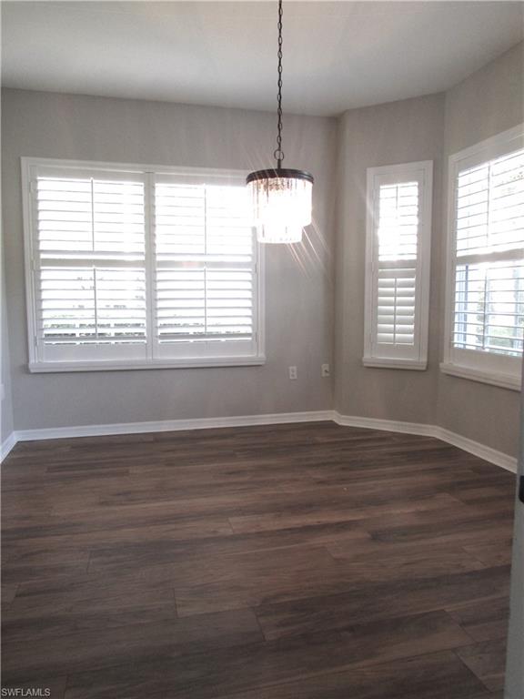 7005 Pinnacle Lane, Unit 1501 Naples, FL 34110 - Photo 18 of 45 a view of an empty room with wooden floor and a window