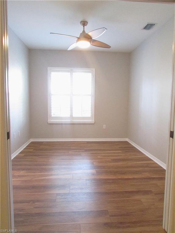 7005 Pinnacle Lane, Unit 1501 Naples, FL 34110 - Photo 24 of 45 wooden floor in an empty room with a window