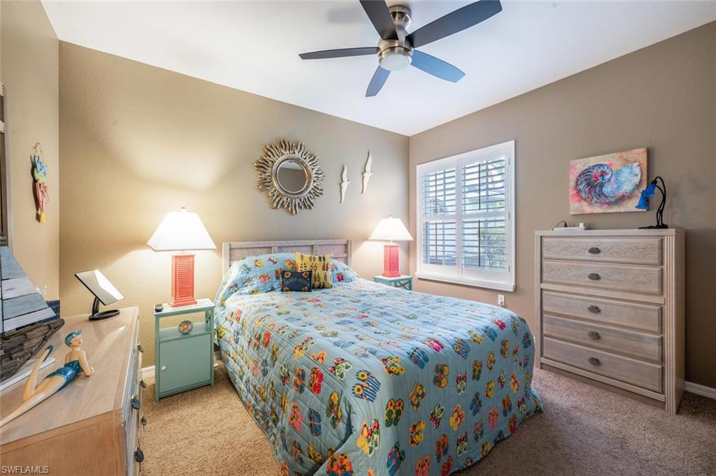 7005 Pinnacle Lane, Unit 1501 Naples, FL 34110 - Photo 25 of 45 a bedroom with a bed and a chandelier