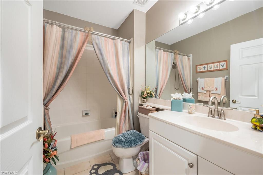 7005 Pinnacle Lane, Unit 1501 Naples, FL 34110 - Photo 27 of 45 a bathroom with a sink a toilet and a mirror