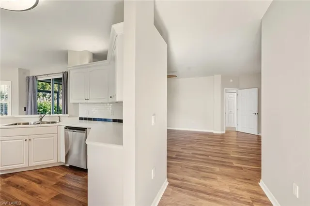 a kitchen with a sink cabinets stainless steel appliances and view living room