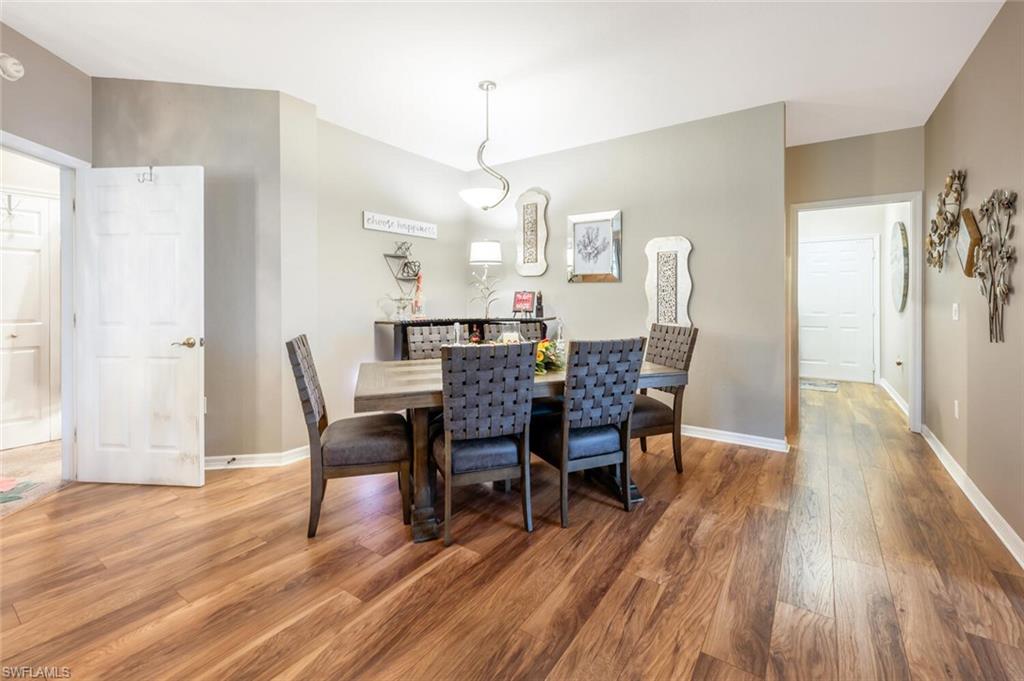 7005 Pinnacle Lane, Unit 1501 Naples, FL 34110 - Photo 5 of 45 a view of a dining room with furniture and wooden floor