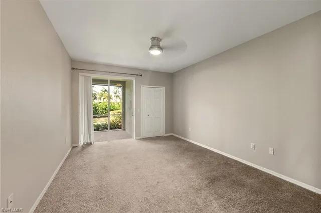 an empty room with windows and a ceiling fan