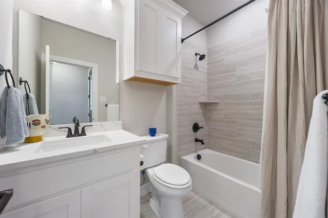 a bathroom with a sink toilet vanity and shower