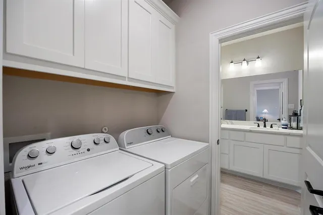 a view of washer and dryer with bathroom in the background