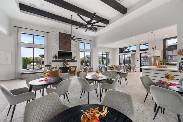 a kitchen with stainless steel appliances a refrigerator a sink dishwasher a oven and a dining table with wooden floor