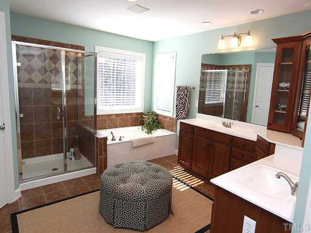 8232 Clarks Branch Drive Raleigh, NC 27613 - Photo 9 of 11 a spacious bathroom with a tub sink shower and mirror