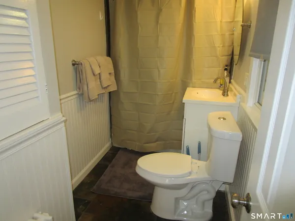 a white toilet sitting next to a shower
