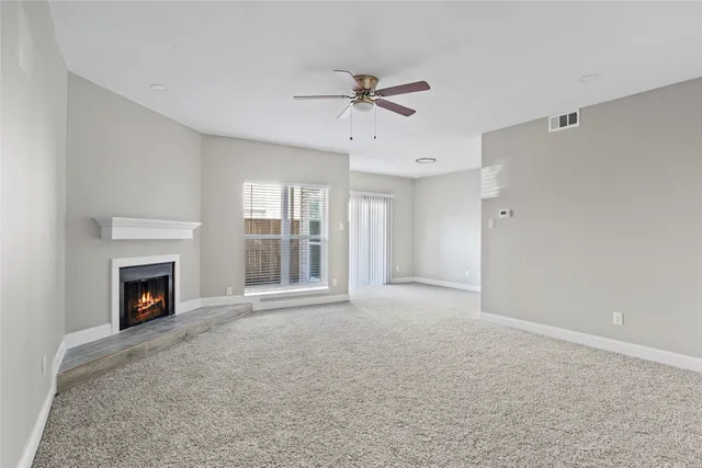 a view of an empty room with a fireplace and a window
