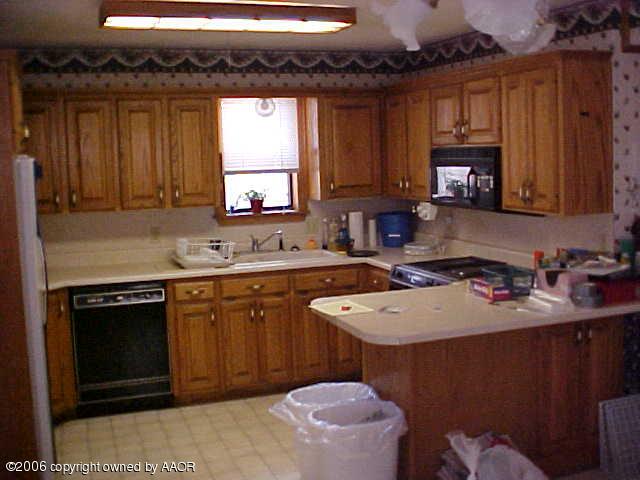 4420 South Ong Street Amarillo, TX 79110 - Photo 8 of 12 a kitchen with a sink stove and cabinets