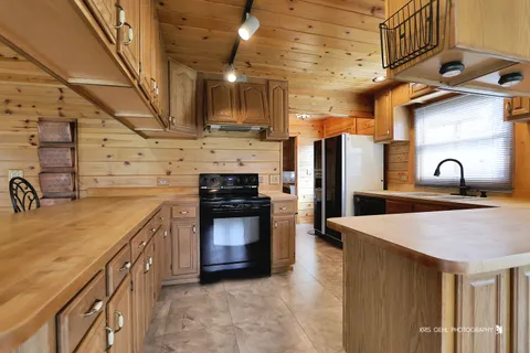 a kitchen with stainless steel appliances granite countertop a sink a stove and a refrigerator
