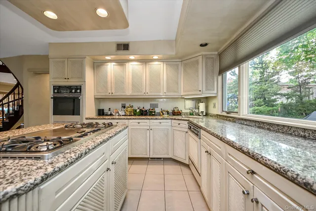 a kitchen with stainless steel appliances granite countertop a sink stove and cabinets