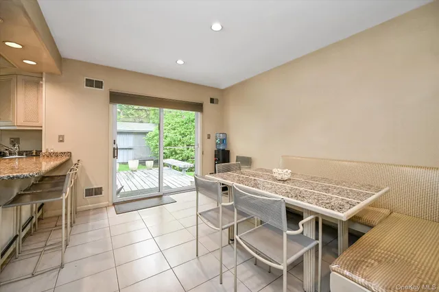 a open kitchen with stainless steel appliances granite countertop a stove a sink dishwasher and a microwave oven with white cabinets