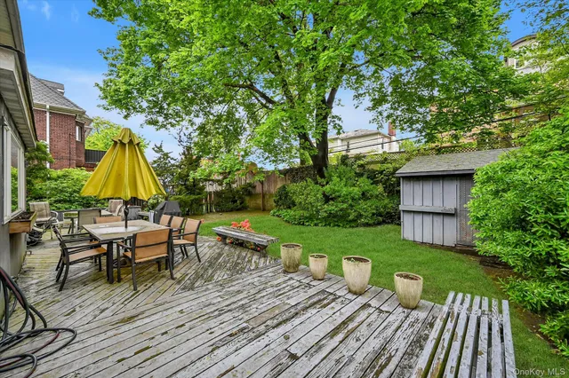 a view of deck with table and chairs under an umbrella with wooden fence