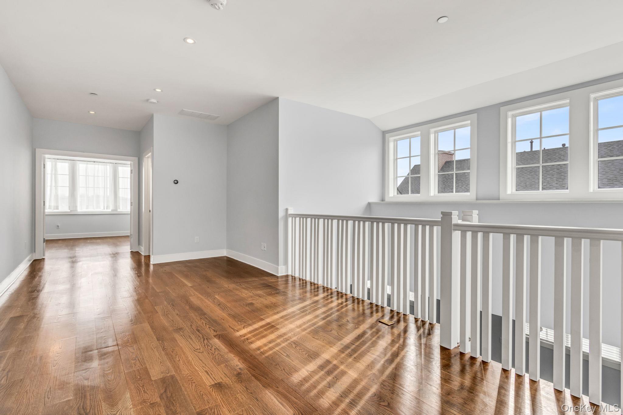 21 Honeysuckle Lane Rye Brook, NY 10573 - Photo 19 of 48 a view of an empty room with wooden floor and a window