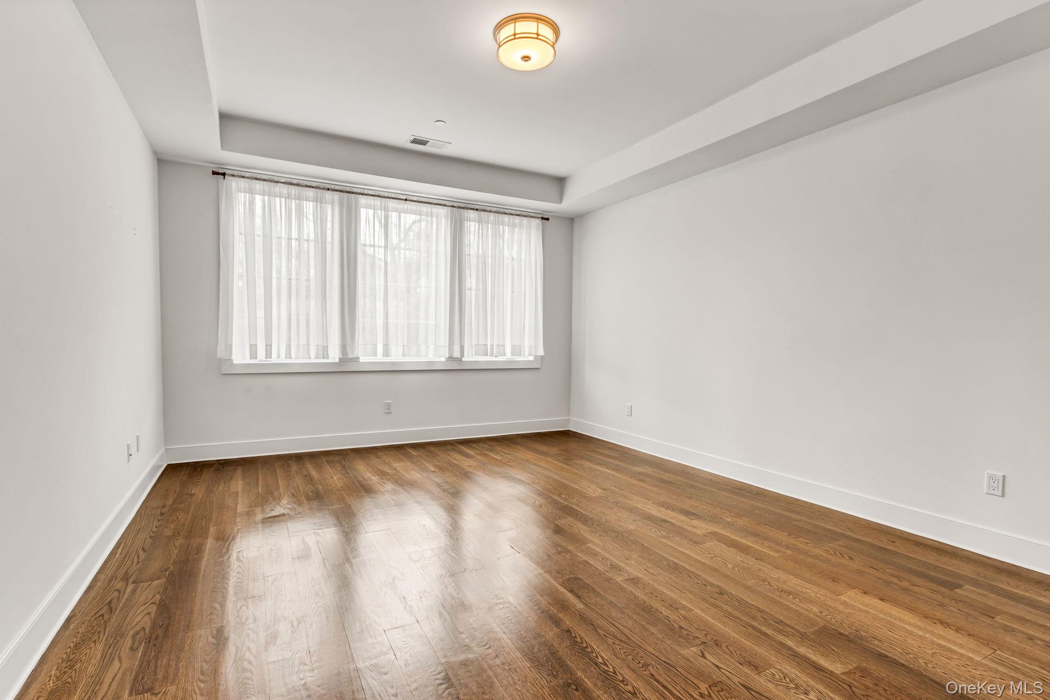 21 Honeysuckle Lane Rye Brook, NY 10573 - Photo 21 of 48 an empty room with wooden floor and windows