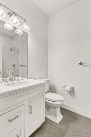 a bathroom with a granite countertop toilet and a sink