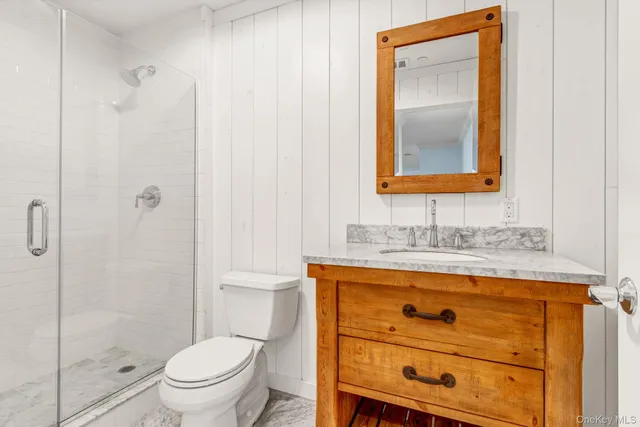 a bathroom with a toilet sink vanity and mirror