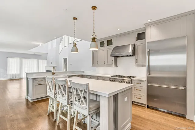a kitchen with stainless steel appliances granite countertop a kitchen island hardwood floor and a sink
