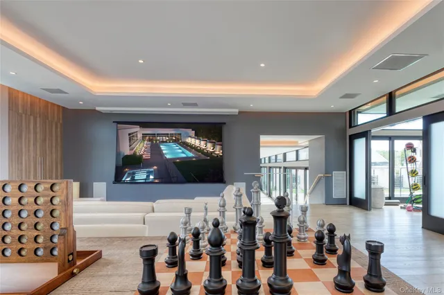 a living room with furniture a flat screen tv and floor to ceiling window