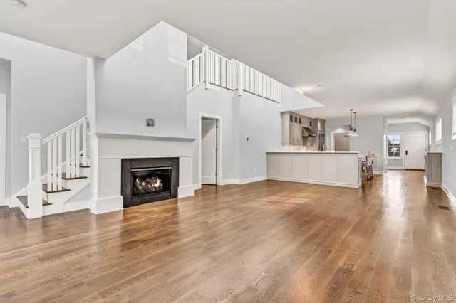 a view of a livingroom with wooden floor and a fireplace