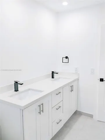 a bathroom with a granite countertop toilet sink and mirror