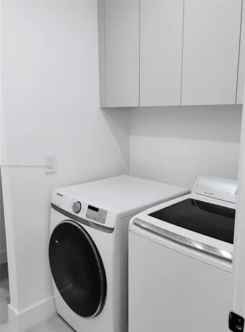 a front view of a house with a yard and a large tree