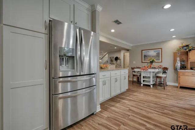 a kitchen with stainless steel appliances a refrigerator and wooden floor