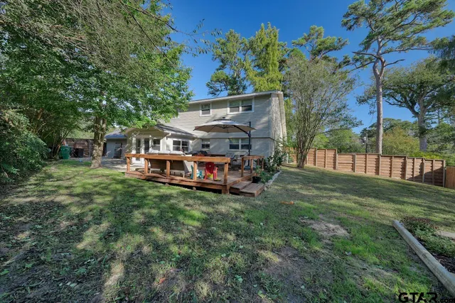 a view of a backyard with a wooden deck and furniture