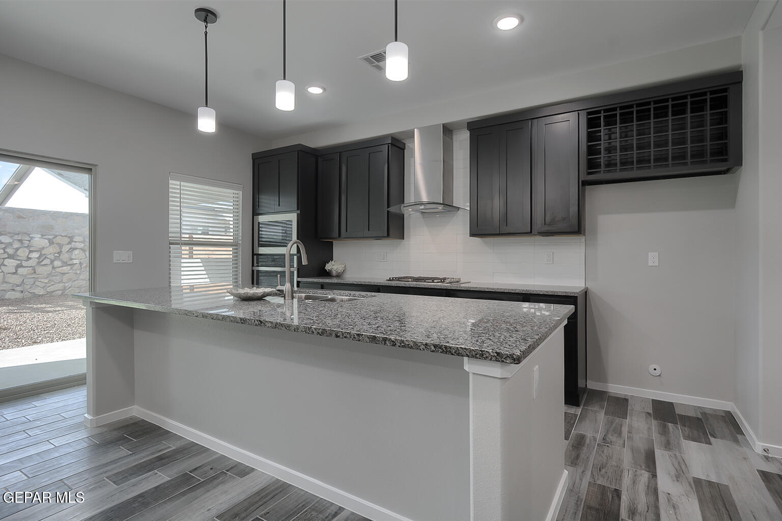 13896 Sky Ranger Avenue El Paso, TX 79928 - Photo 12 of 30 a kitchen with stainless steel appliances granite countertop a sink a oven a refrigerator cabinets and wooden floor