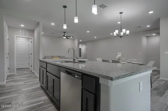 a kitchen with granite countertop a sink stove and cabinets