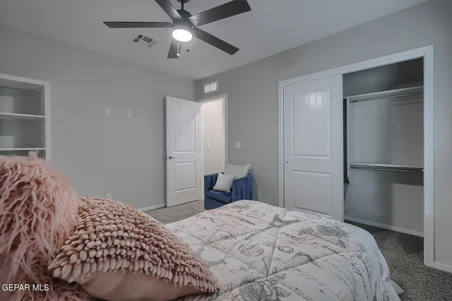 a bedroom with a bed and a ceiling fan