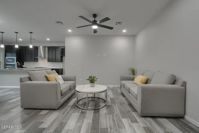 a living room with furniture and a view of kitchen