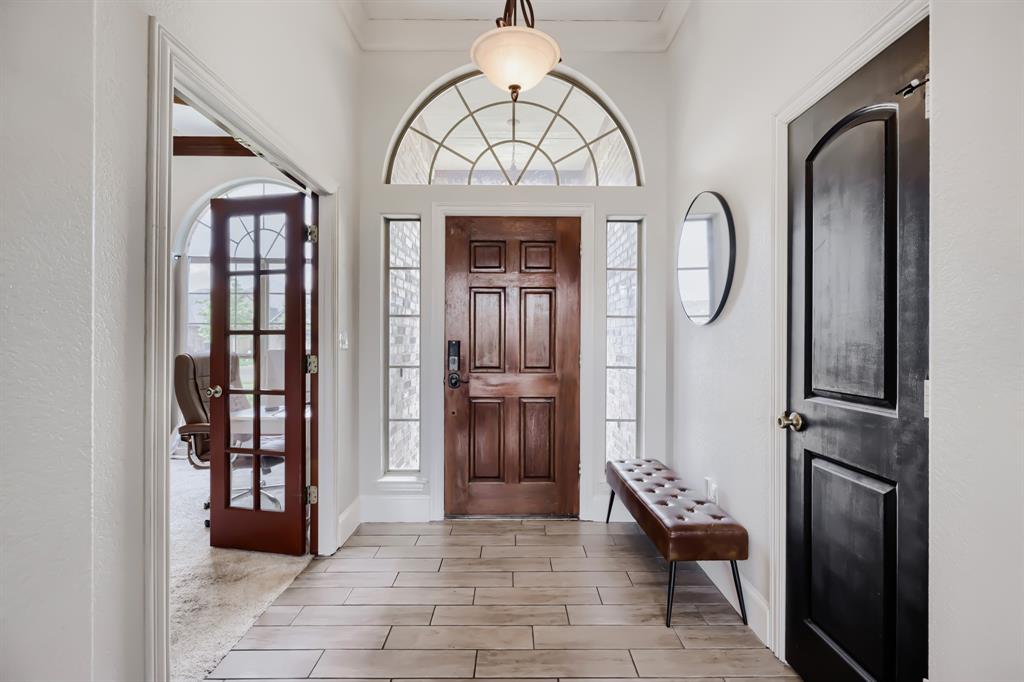 603 Ash Street Pilot Point, TX 76258 - Photo 4 of 28 Entry foyer featuring a wood-panel front door with sidelights and an arched transom window
