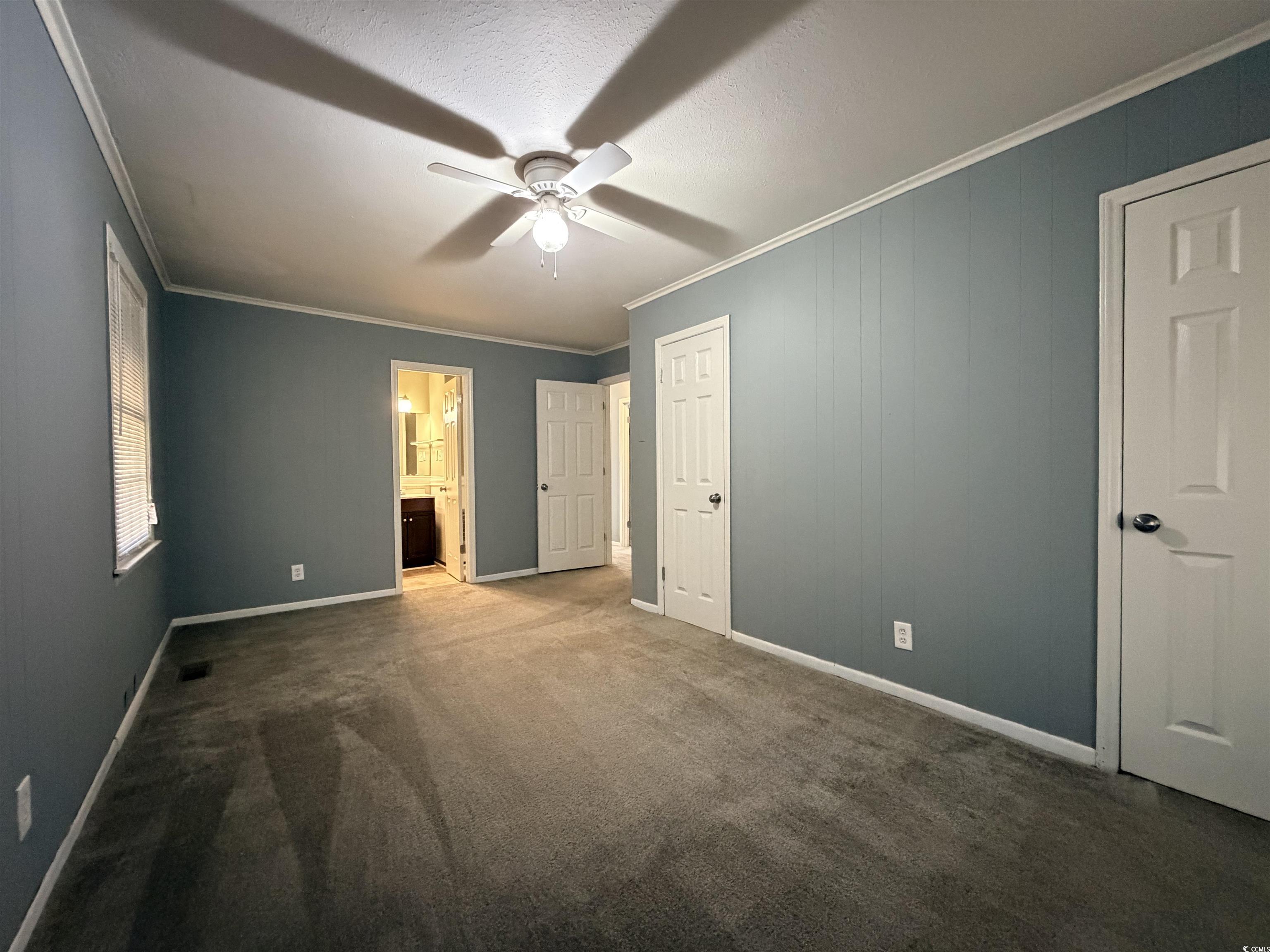 107 Aster Drive Greer, SC 29651 - Photo 11 of 20 Unfurnished bedroom with crown molding, ceiling fan, dark carpet, and ensuite bath