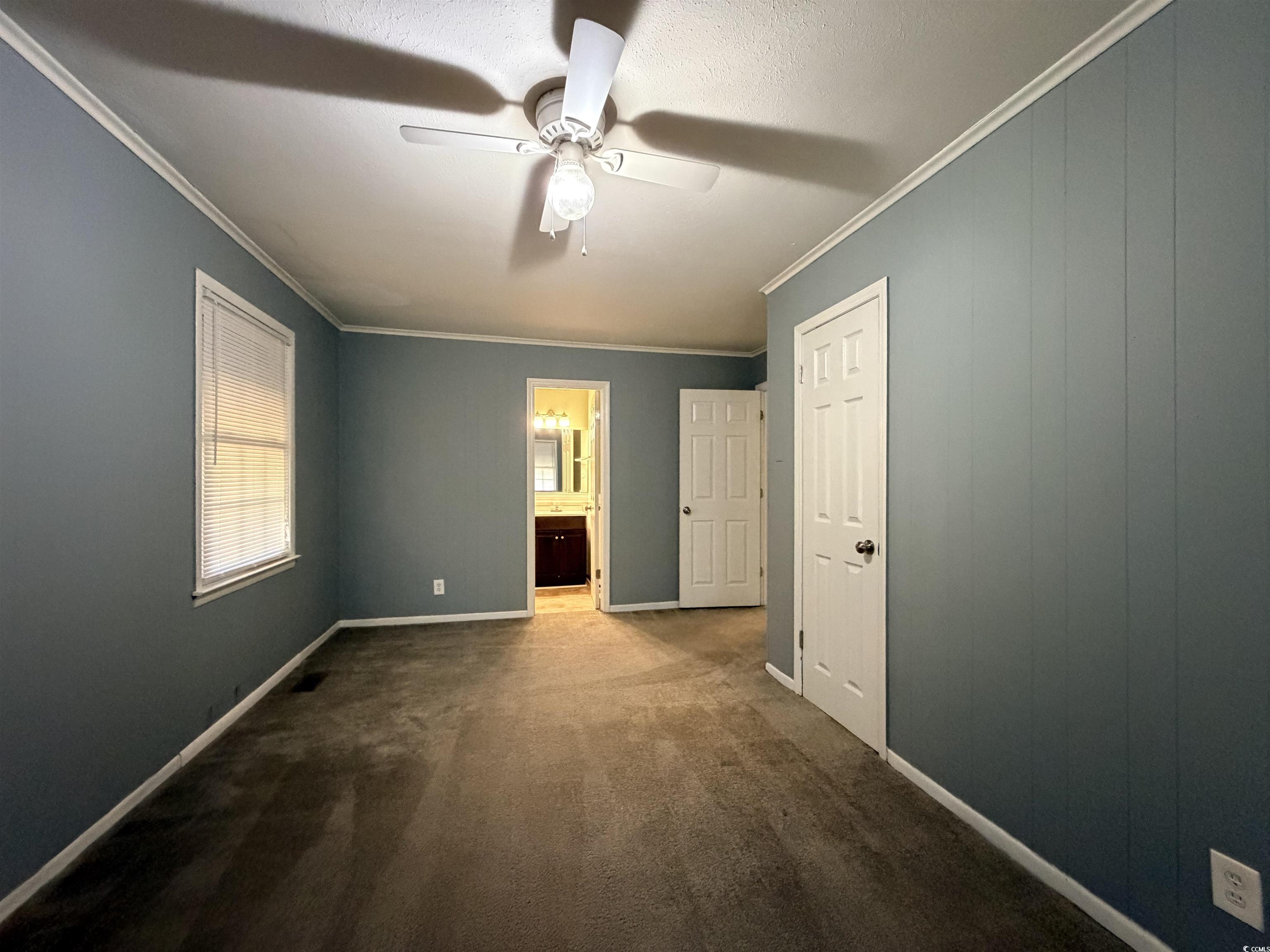 107 Aster Drive Greer, SC 29651 - Photo 12 of 20 Unfurnished bedroom with ornamental molding, ceiling fan, ensuite bath, and dark colored carpet