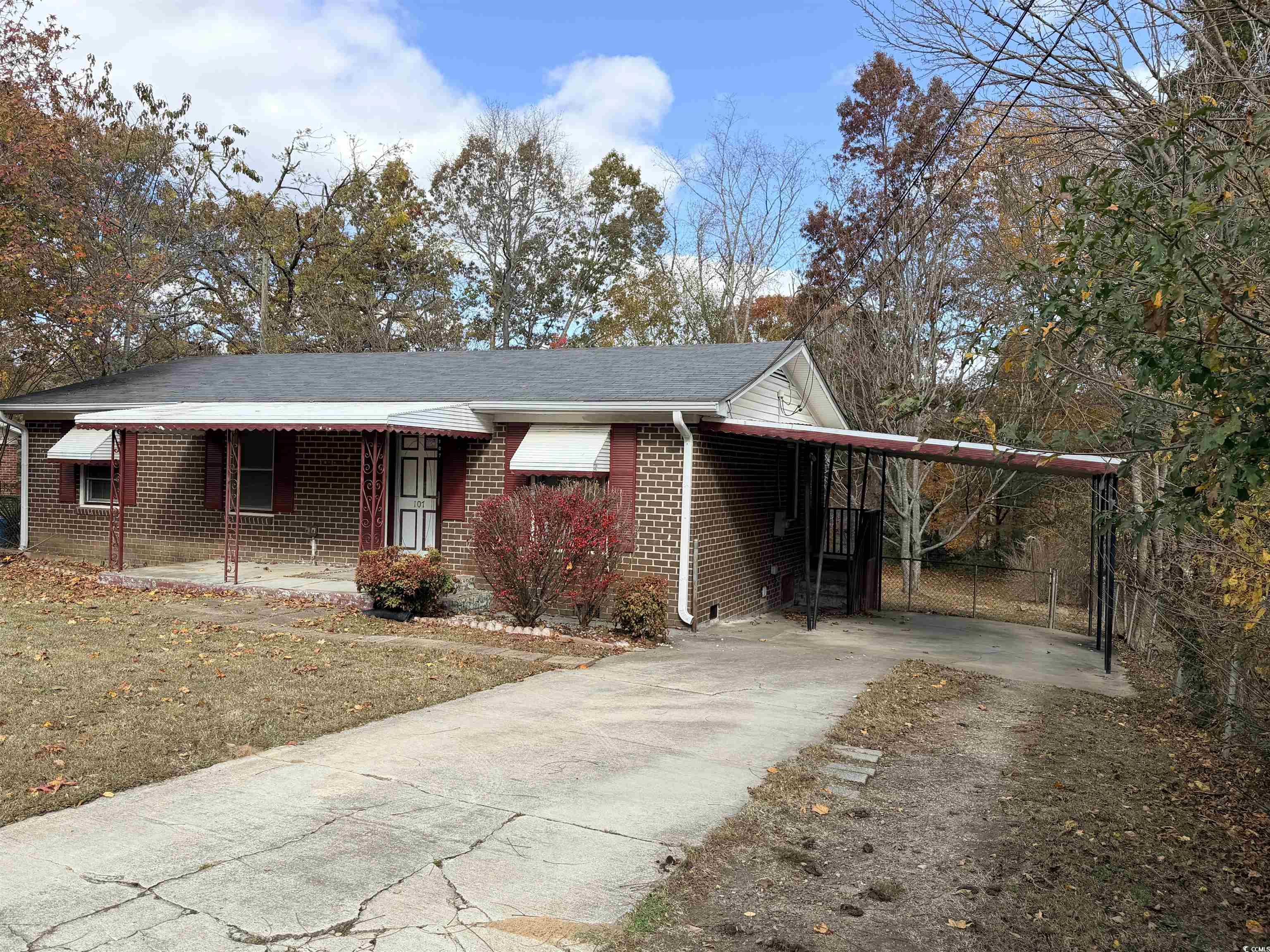 107 Aster Drive Greer, SC 29651 - Photo 2 of 20 Ranch-style house featuring concrete driveway, brick siding, an attached carport, a porch, and a shingled roof