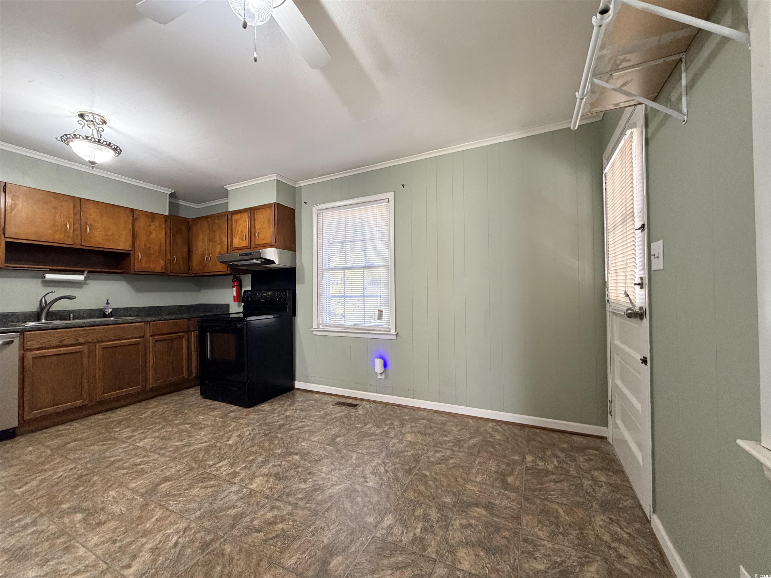 107 Aster Drive Greer, SC 29651 - Photo 8 of 20 Kitchen with crown molding, electric range, dark countertops, wood walls, and under cabinet range hood