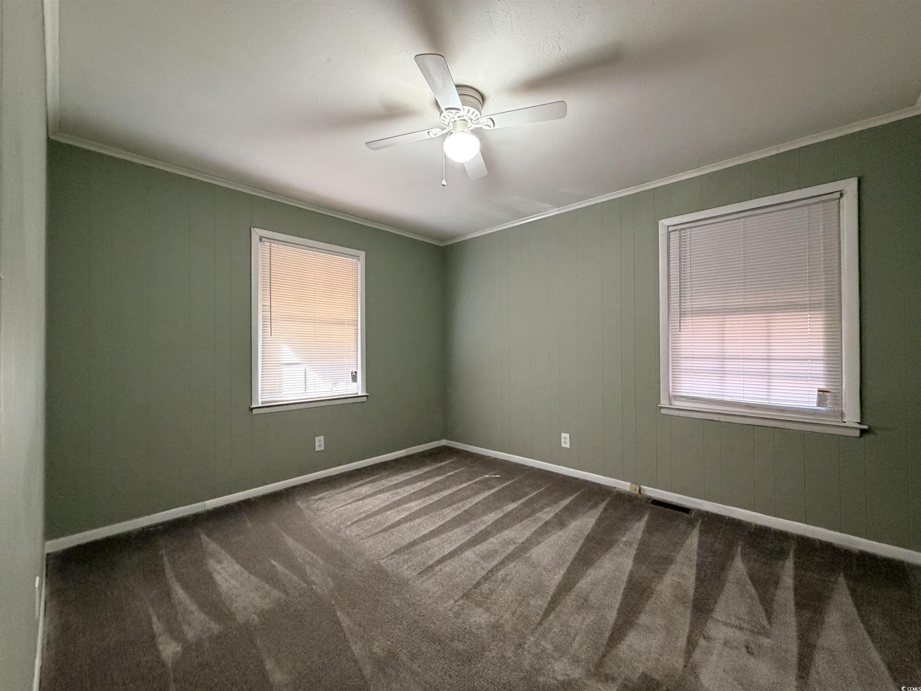 107 Aster Drive Greer, SC 29651 - Photo 10 of 20 Empty room with ornamental molding, dark colored carpet, a ceiling fan, and healthy amount of natural light